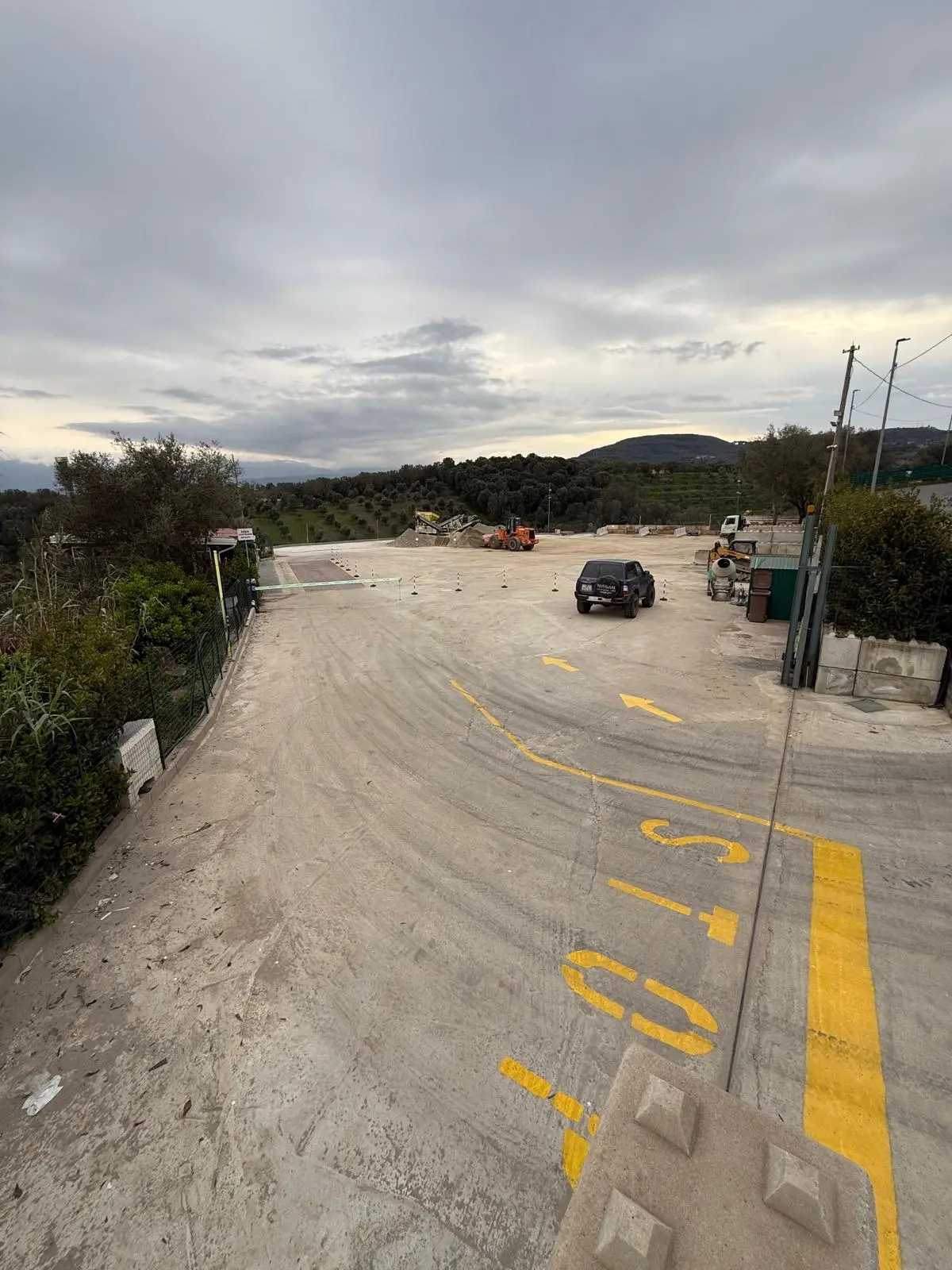 Il piazzale di accesso all'impianto visto dall'ingresso, con la segnaletica gialla che indica il percorso dei mezzi